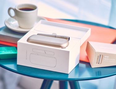 A package containing a gold IQOS device and holder.