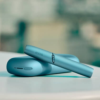 Turquoise IQOS Originals Duo  holder and pocket charger on table.