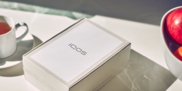 An unopened IQOS device box on a table.
