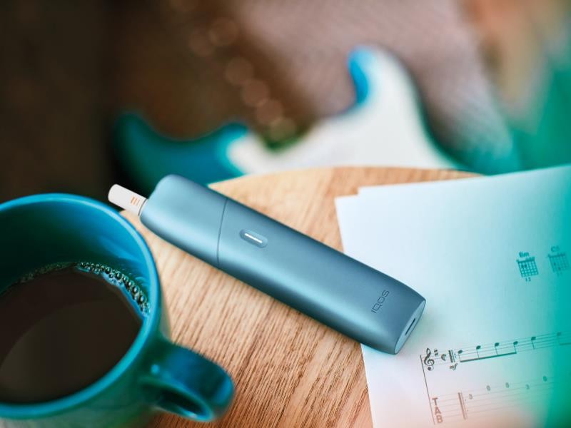 Turquoise IQOS Originals One device on a coffee table